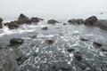 Wide view of waves beating on beach. Rocky sea shore