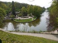 Wide water canal with fountain. Around it there are pairs with green flower beds, on one of which the number of flowers Royalty Free Stock Photo