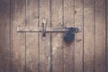 Wide wooden door with black iron hanging padlock Royalty Free Stock Photo