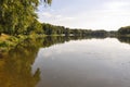 Wide yellow river is slow flowing. Early autumn. Sunny weather and brightgreen trees on the banks fron the both sides