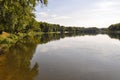 Wide yellow river is slow flowing. Early autumn. Sunny weather and brightgreen trees on the banks fron the both sides