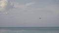 Widebody airplane approaching over ocean