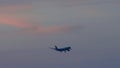 Widebody airplane final approaching at sunset