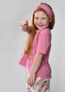 Widely smiling little red-haired girl child turning from back pointing to camera Royalty Free Stock Photo