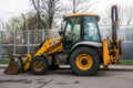 Widespread model of universal backhoe loader of JCB Company Great Britain of recognizable yellow colour.