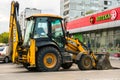 Widespread model of universal backhoe loader of JCB Company Great Britain of recognizable yellow colour.