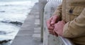 Widower feeling alone and sad on a walk. Closeup of a mature man holding his wedding ring while standing at a beach on a