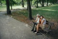 A widower is sitting on a bench in the park with his granddaughter, mourning his deceased wife.