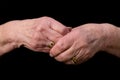 Widows hands clasped in grief on a black background. Royalty Free Stock Photo