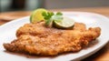 Wiener schnitzel with lime on a white plate.