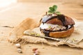 Wierd burger with vanilla ice cream and chocolated confetti on wooden background.