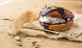 Wierd burger with vanilla ice cream and chocolated confetti on wooden background. Royalty Free Stock Photo