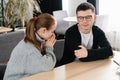 Wife asking for forgiveness to her husband after conflict sitting in the cafe