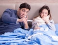 Wife caring for sick husband at home in bed