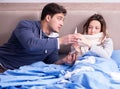 Wife caring for sick husband at home in bed