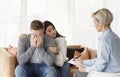 Wife Comforting Crying Husband During Psychotherapy Appointment In Psychologist`s Office Royalty Free Stock Photo