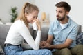 Wife crying sitting together with husband on couch at home Royalty Free Stock Photo