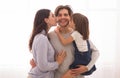 Wife and daughter kissing happy man on both cheeks Royalty Free Stock Photo