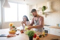 Wife drinking coffee and watching husband cooking salad Royalty Free Stock Photo