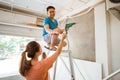 Wife gives husband bolts to install ceiling trusses while renovating