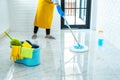 Wife housekeeping and cleaning concept, Happy young woman in blue rubber gloves wiping dust using mop while cleaning on floor at Royalty Free Stock Photo