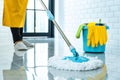 Wife housekeeping and cleaning concept, Happy young woman in blue rubber gloves wiping dust using mop while cleaning on floor at