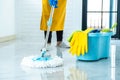 Wife housekeeping and cleaning concept, Happy young woman in blue rubber gloves wiping dust using mop while cleaning on floor at Royalty Free Stock Photo