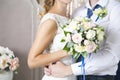 The wife of the husband embraces a wedding bouquet. Newlyweds. Wedding day