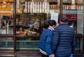 A couple of people window shop at food outlet, Shanghai.