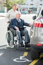 Wife pushing disabled husband towards car