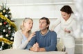 Wife quarrels with her husband in kitchen on christmas eve, and elderly mother calms son Royalty Free Stock Photo