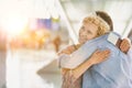 Wife reuniting with his husband in airport with yellow lens flare