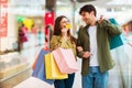 Wife Showing Credit Card To Husband Shopping Together In Hypermarket Royalty Free Stock Photo