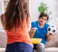 Wife unhappy that husband is watching football Royalty Free Stock Photo