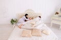 Wife yelling at daughter, husband sleeping on white bed in room Royalty Free Stock Photo