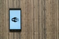 Wifi logo on smartphone screen on wooden background.
