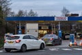 Wigan, UK: March 10, 2022: Queuing cars waiting to buy fuel at a Tesco petrol filling station as British drivers panic