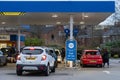 Wigan, UK: March 10, 2022: Queuing cars waiting to buy fuel at a Tesco petrol filling station as British drivers panic