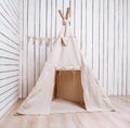 Wigwam in a room with wooden planked walls