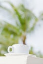 Wihte coffee cup against palm tree background