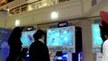 Wii staff demonstrates with people playing car racing game