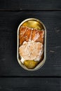 Wild Alaska Salmon Canned smoked fish, in tin can, on black wooden table background, top view flat lay