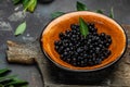 Wild berries, Northern berry: lingonberry, blueberry, Bowl of fresh maqui berry on dark background, top view