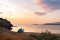 Wild camping on the beach in sunset. Beautiful orange sky and clear calm sea water in the background