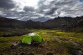 Wild camping in a bright lime green tent in icelandic mountains