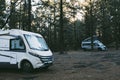 Wild campsite with couple of camper vans parked. Wild and scenic forest woods detination for transport travel vacation and