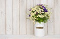 Wild chamomile flowers bouquet on table over wooden planks background