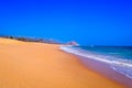 Wild Empty Tropical beach, vibrant yellow sand, bright blue sky, crystal clear waters with water crashing on the shore at daytime Royalty Free Stock Photo