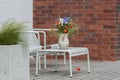 Wild flower bouquet (Cornflowers, chamomiles wheat and poppies) in terracotta vase on summer terrace.