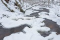 The wild frozen river in the winter wood atfter snow storm, the wild nature, ice, snow-covered stones, peace and quiet